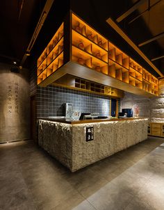 an empty counter in a restaurant with lights on the wall and tiled walls behind it