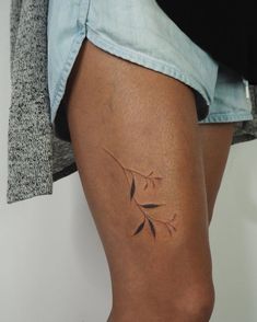 a woman's leg with a small tattoo on the lower half of her thigh