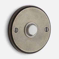 a metal button with two holes in the middle and one hole on the outside of it