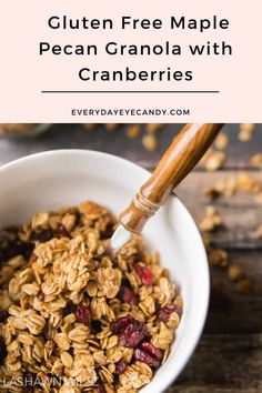 granola with cranberries in a white bowl on top of a wooden table