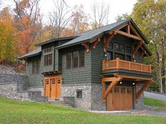 a large house with two garages on the front and second story, surrounded by trees