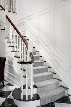 an elegant staircase with black and white marble flooring