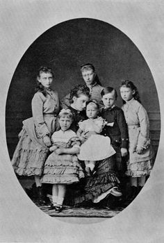 an old black and white photo of children posing for a picture with their mother in the middle