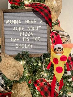 a christmas tree decorated with an elf's pizza sign and other holiday decor items