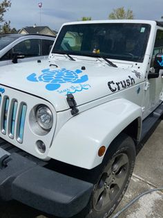 a white jeep parked in a parking lot next to another car with the word crutch on it