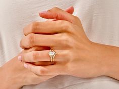 two hands holding each other while one holds the other's hand with a diamond ring on it