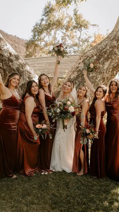 a group of women standing next to each other in front of a tree