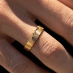 a woman's hand with a gold ring on it