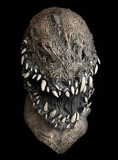 an alien head with teeth and fangs on it's face, against a black background