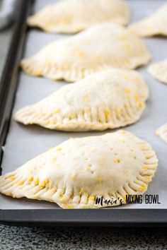 several pastries on a baking sheet ready to be baked in the oven for dinner