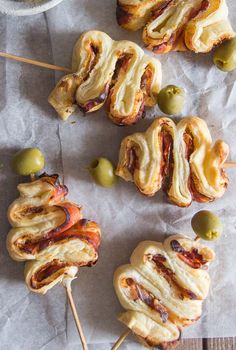 several appetizers on sticks with olives and meat in the middle, ready to be eaten