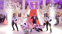 a group of people standing around each other in front of a staircase with musical instruments