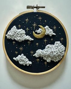 an embroidery project with clouds, stars and the moon