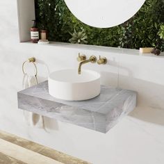 a white sink sitting under a mirror next to a wall mounted faucet in a bathroom