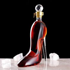 a glass shoe shaped bottle sitting on top of ice