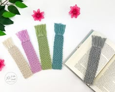 four crocheted book ends sitting on top of an open book next to flowers