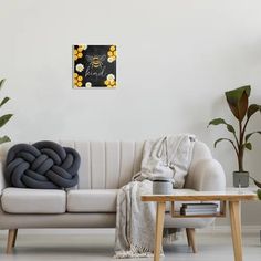 a white couch sitting next to a wooden table with a blanket on top of it