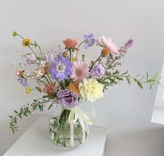 a vase filled with lots of different colored flowers