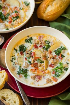 two bowls of soup with bread on the side