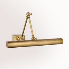 an antique brass finish wall light with two lights on each side and a long arm