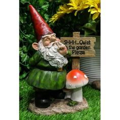 a garden gnome sitting next to a sign