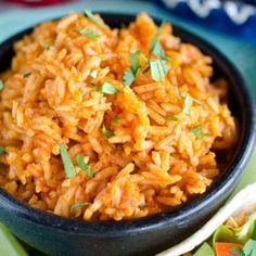 a close up of a bowl of rice on a plate with bread and vegetables in the background