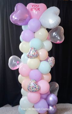 a balloon tower with balloons and hearts on it