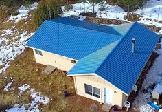 an aerial view of a house in the middle of winter with snow on the ground