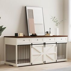 a dog crate with a mirror on top of it next to a potted plant