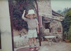 a young boy wearing a hat and standing on a skateboard