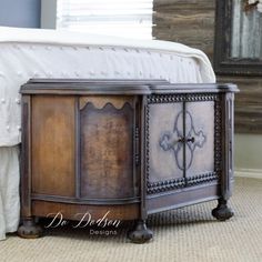 a bed sitting next to a wooden dresser on top of a carpeted bedroom floor