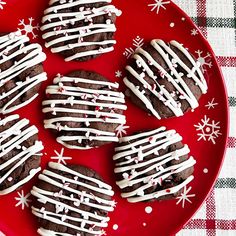 chocolate cookies decorated with white icing on a red plate