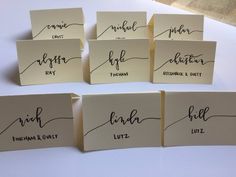 six place cards with calligraphy on them