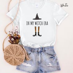 Thank you for supporting a small, woman-owned business! Striking the perfect balance between comfort and sass, this unisex heavy cotton tee is perfect for everyday use and a fun addition for any witch (I mean adult) during the Halloween season. ABOUT: .: Unisex .: Classic fit .: Consists of 100% cotton for comfort that is sustainable and durable.  .: The tear-away label means a scratch-free experience with no irritation or discomfort. .: Runs true to size SIZES & COLORS: .: Sizes: Please check the appropriate size charts on the listing (last picture). .: Colors are posted in each photo listing. .: Actual colors may vary due to computer monitors displaying colors differently. CARE INSTRUCTIONS: .: Machine wash warm, inside-out, gentle cycle .: Wash with similar colors .: Use non-chlorine bl Witch Tshirt, In My Era, Halloween Moms, Basic Witch, Witch Halloween, Witch Aesthetic, Halloween Season, Computer Monitors, Size Charts