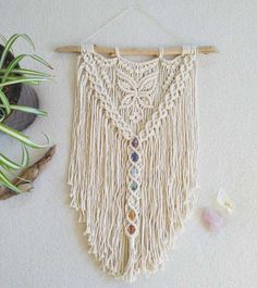 a macrame hanging on a wall next to a potted plant and other items