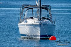 a white boat floating on top of a body of water next to a red buoy