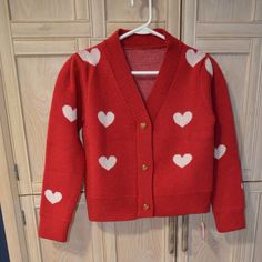 Here’s A Darling Cropped Cardigan That Will Take You Right Through Christmas And On To Valentine’s Day! From Chicwish And Brand New, It Is A Size Small In A Soft Acrylic Knit, Featuring Gold Heart Shaped Buttons Down The Front. The Background Of The Sweater Is A Deep Red, With White 2 Inch Wide Hearts Woven Into The Fabric. It Is Cropped, Measuring 20 Inches From Shoulder To Bottom Hem. The Shoulder Boasts A Slight Pleat, Offering The Puffed Look Of The Moment. What A Delightful Piece To Introdu Cute Red Spring Cardigan, Cute Red Sweater For Fall, Cute Red Winter Sweater, Cute Red Long Sleeve Sweater, Fitted Red Knit Cardigan, Cute Red Long Sleeve Cardigan, Play Closet, Cropped Knit Cardigan, Alice Costume