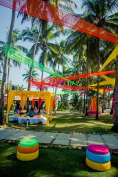 colorfully decorated tables and chairs under palm trees