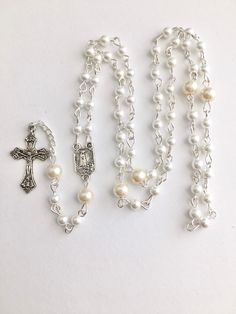 Handmade rosary was made with silver metal wire, 4mm white and 6mm off white faux glass pearls. Images of Our Lady on both sides of the rosary center piece. Comes in a gift pouch White Rosary Bracelet For First Communion, Pearl Rosary For First Communion, Spiritual Style, Spiritual Pearl Rosary For First Communion, White Pearl Rosary Bracelet For Baptism, White Pearl Rosary As A Gift, Pearl White Rosary For First Communion, White Pearl Rosary As Gift, White Crucifix Rosary With Miraculous Medal, White Spiritual Rosary With Miraculous Medal