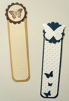 two bookmarks with butterflies on them and one has a butterfly in the middle, while the other is made out of paper