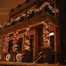 a building with christmas lights on the windows and balconies in front of it