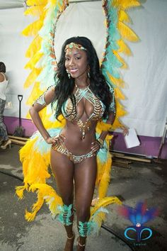 a woman in a belly dance costume posing for the camera with feathers on her head