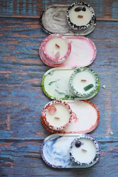 four small candles are lined up on a table