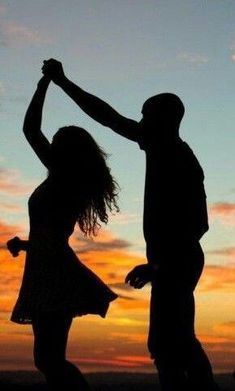 two people are dancing in front of the sunset