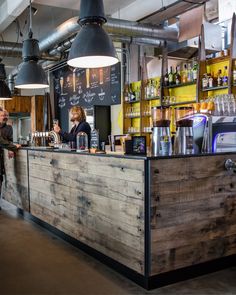 two people are standing at the bar in a restaurant