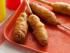 some food is sitting on a red tray with chopsticks in front of it