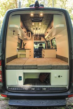 the back end of an rv with its doors open and seats folded down in front