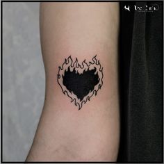 a heart shaped tattoo with flames on the back of it's left arm,