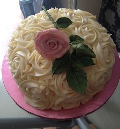 a cake decorated with white icing and pink flowers