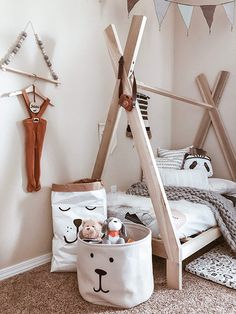 a child's bedroom with a teepee tent bed and toy storage bins